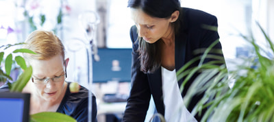 Mitarbeitende im Gespräch im Büro Mitarbeitende im Gespräch im Büro